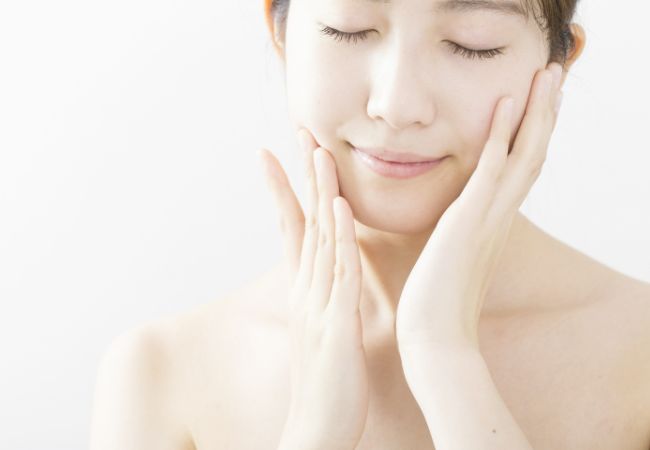 頬に手を当て目を閉じている女性